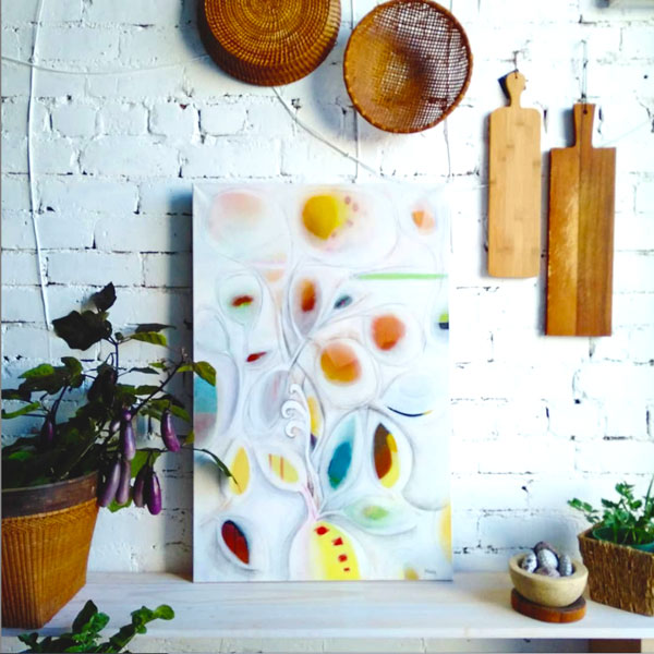 a really nicely styled photo of one of mandys botanical abstract canvases against a white brick wall next to eggplants, rocket and other vegetables from the garden