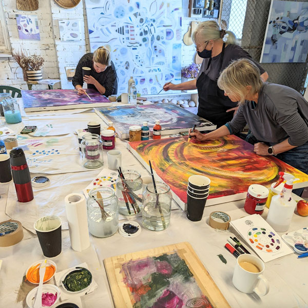 women at a painting workshop inside the Art Garden