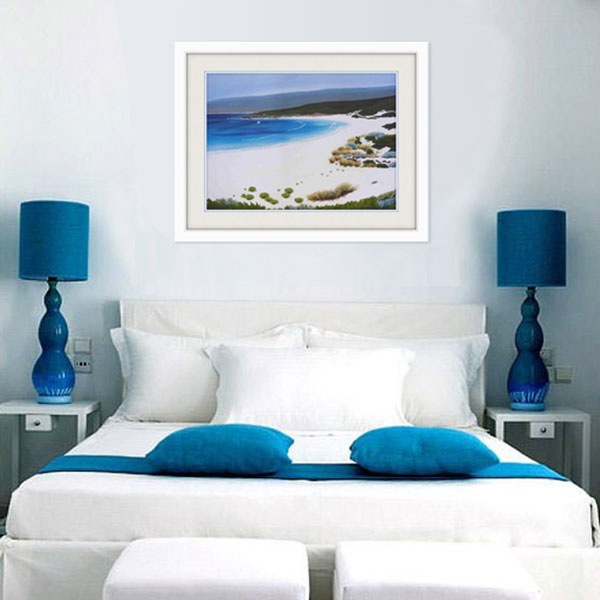 an insitue photograph of the smith beach limited edition styled in white for a bedroom interior with blue highlights  matching the azure blu colour of the sea in the picture