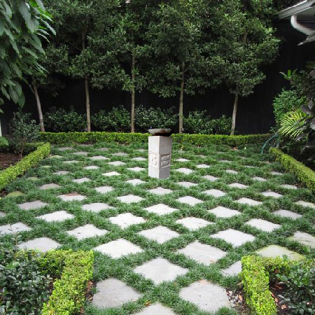 a photoshopped garden with mandys birdbath on a checkerboard patterned pavers