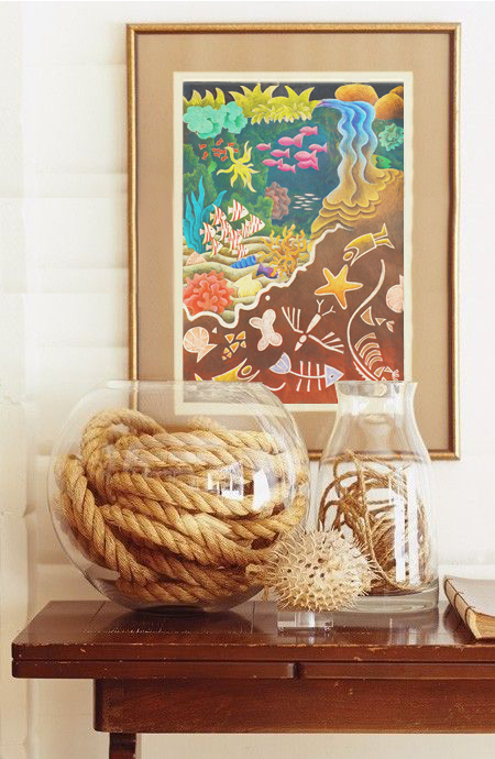 A framed print of Dreamtime in an ocean themed table top vignette 